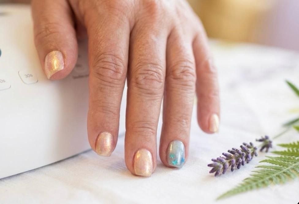 Helle Maniküre mit goldenem Akzent